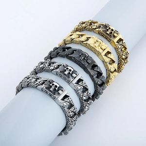 Detailed macro view of skull-embossed cuban link bracelets in gold, silver, and black finish