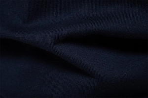 Macro de maille en coton bleu marine montrant la texture fine et les détails côtelés