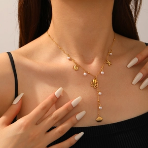 Detailed view of gold Y-chain necklace featuring sea turtle, starfish and octopus charms