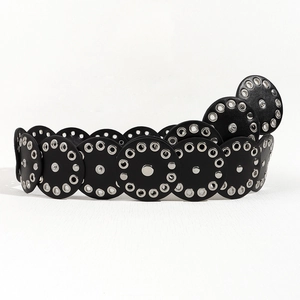 Detail of black leather waist belt with silver metal grommets and rivet accents
