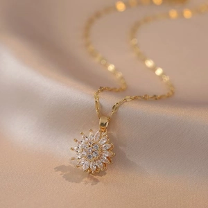Macro shot of a golden sunflower necklace with sparkling zircon petals on silk