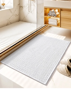 Close-up of white chenille bath mat with non-slip texture in modern bathroom setting