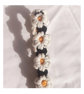Detailed view of hand-woven daisy crochet strap with white petals and yellow centers