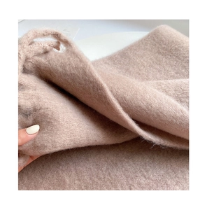 Detailed close-up showing soft thick plush texture and fabric weight of brown winter scarf