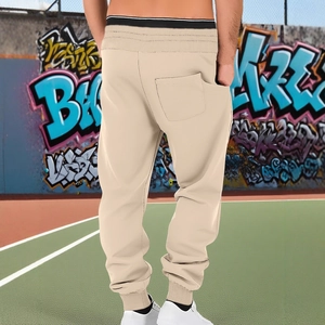 Men's casual beige jogger pants with elastic waist and back pocket on tennis court