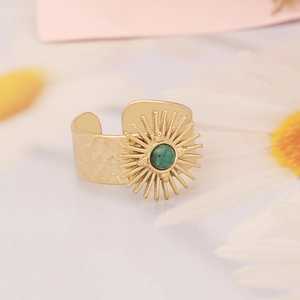 Detail of sunburst gold open ring with round green turquoise stone and vintage finish
