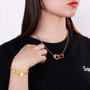 Close-up of a model wearing golden handcuff-style necklace and bracelet jewelry set