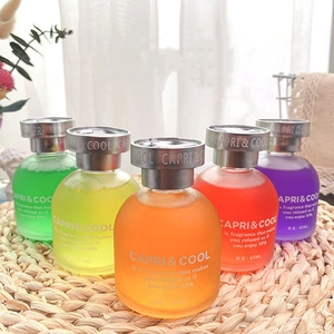 Row of colorful 65ml liquid aromatherapy glass bottles on a woven mat for home and car