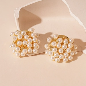 Macro shot of vintage pearl cluster earrings with gold metal base and French retro style