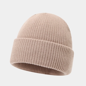 Detailed view of the ribbed knit texture and wide folded cuff of the warm beige beanie cap