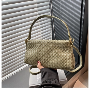 Dettaglio della borsa a tracolla intrecciata verde salvia con texture in pelle e fibbia