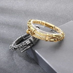Detailed close-up of punk style braided cable bracelets in gold and gunmetal gray finishes