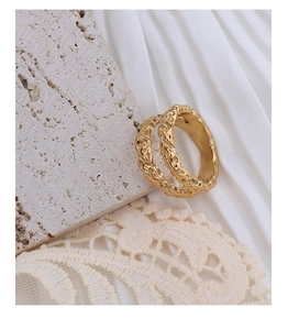 Detailed view of 18k gold layered ring with hammered texture on marble stone background