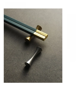 Macro detail of hourglass metal chopstick rest with elegant gold and green design
