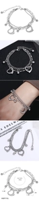 Detailed view of triple-layer stainless steel bracelet with heart charm and sphere beads