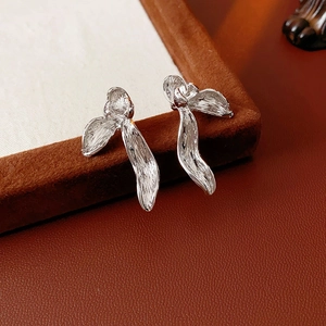 Close-up of silver pleated orchid petal earrings with a brushed metal texture finish