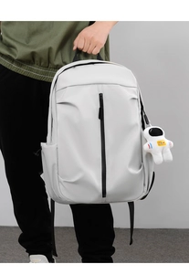 Close-up of white water-resistant Oxford backpack with cute astronaut plush keychain detail
