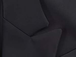 Close-up of the black herringbone wool blazer lapel showing high-quality fabric texture