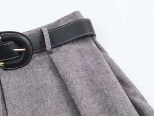 Detail of grey herringbone fabric texture and black leather belt with gold buckle pin