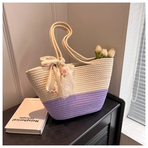 Detail of woven cotton shoulder tote with purple trim and floral lace bow decoration