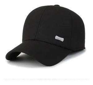 Close-up of black baseball cap with side silver metal logo and high-quality wool texture