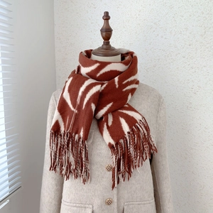 Detail of red and white striped winter scarf featuring soft wavy pattern and fringe edges