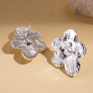 Minimalist silver flower stud earrings with pearl center and metallic petal texture