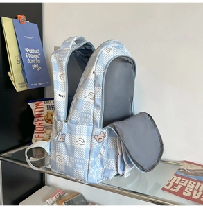 Detail of blue plaid school backpack interior compartments and cute bear patterns