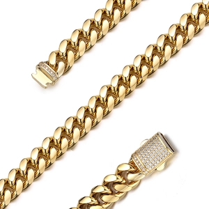 Detail of gold Cuban chain necklace featuring crystal-encrusted and smooth clasp designs