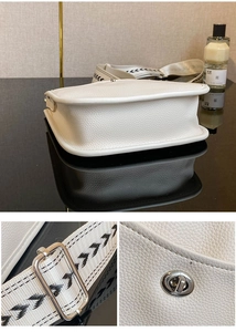 Detail der weißen Umhängetasche aus Leder mit Lychee-Muster, breitem Gurt und Silberverschluss