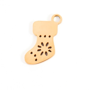 Close-up of golden Christmas stocking charm with hollowed-out flower patterns for DIY jewelry