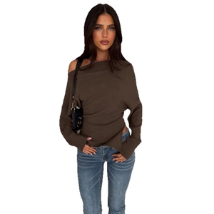 Detail eines braunen One-Shoulder-Strickoberteils kombiniert mit blauer gewaschener Jeans