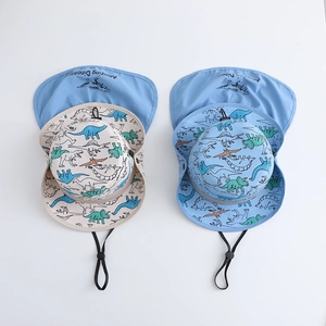 Detail view of beige and blue dinosaur sun hats with neck flaps and adjustable chin straps