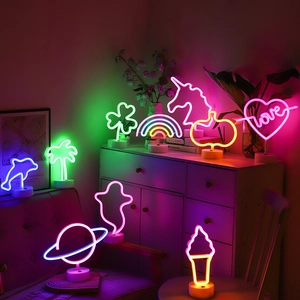 Various neon LED night lights like flamingo and heart with white round bases for decor