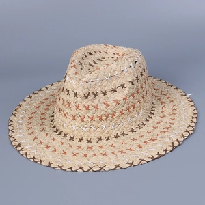 Detailed view of colorful cross-stitching on a bohemian straw sun hat with woven texture