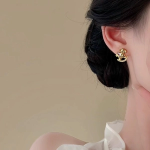 Elegant gold horse stud earrings with sparkling zircon crystals worn by a model
