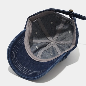 Detail of Los Angeles embroidery and metal buckle on dark blue denim baseball cap
