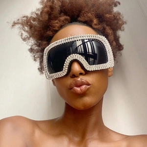 Close-up of oversized square sunglasses with sparkling rhinestone frame and black lenses
