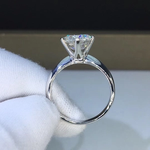 Macro side view of a classic four-prong solitaire ring with a brilliant round-cut stone