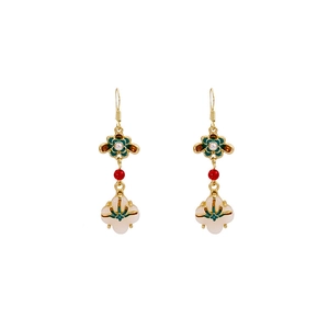 Detail of vintage Chinese earrings with green enamel and white jade flower pendant