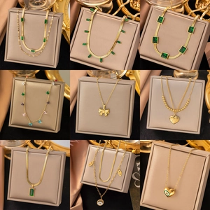 Set of nine luxury gold titanium steel necklaces with emeralds and trendy pendants