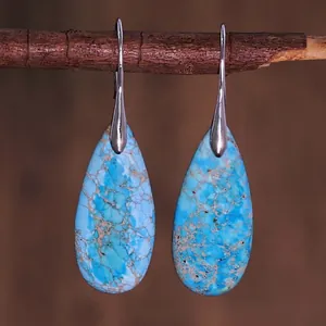 Vintage teardrop earrings with blue imperial stone and silver hooks on wood