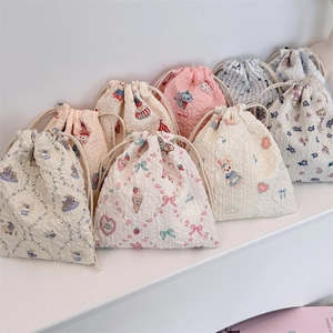 Assorted seersucker drawstring bags with cute animal patterns on a white display shelf
