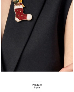 Detailed view of a Christmas stocking brooch pin with enamel finish on a black blazer