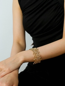 Detail of 18k gold plated vintage lace floral hollow cuff bracelet on female model arm
