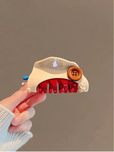 Gros plan détaillé d'une pince à cheveux fromage avec bouton et dents rouges