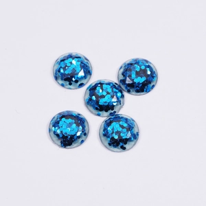 Detail of round resin cabochons filled with shimmering blue hexagonal sequins for DIY crafts
