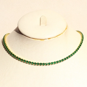 Close-up of green tennis necklace with vibrant round-cut zircon stones in gold plating