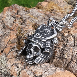 Gothic skull helmet pendant in vintage silver finish on a rustic wood bark background