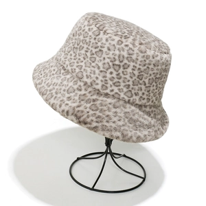 Close-up of leopard print faux fur bucket hat on a metal stand showing plush texture